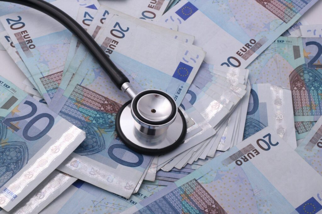 Silver and black stethoscope on 100 rupee bill